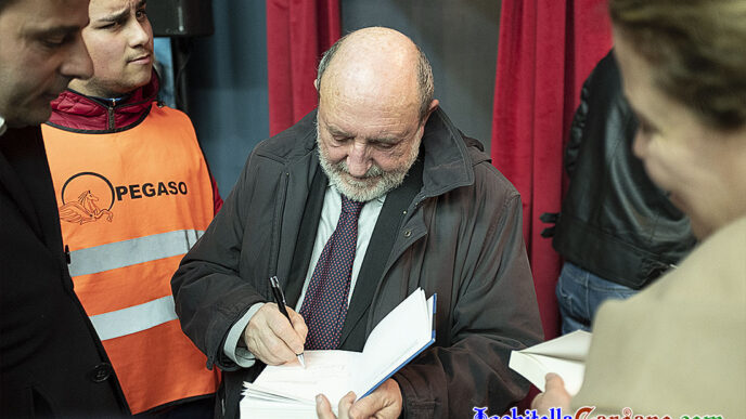 Umberto Galimberti mentre fotografa una copia del suo libro